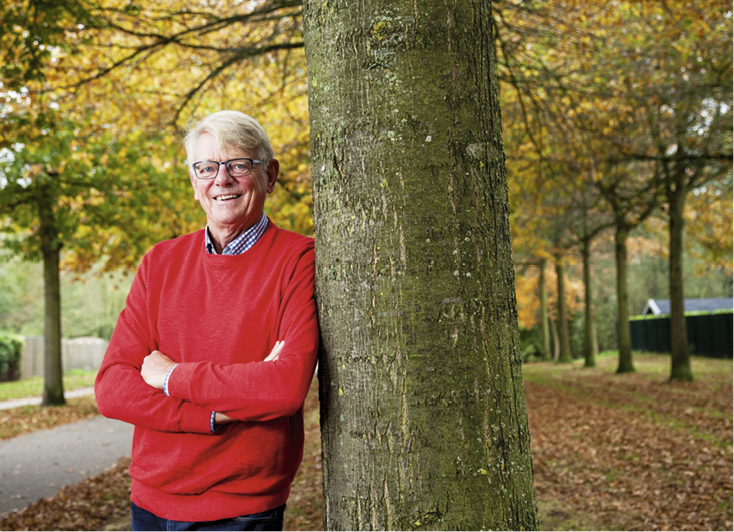 Portretfoto (kleur) van Jan Boonstra in de natuur (leunend tegen een boom in het herfstseizoen bij milde temperatuur)