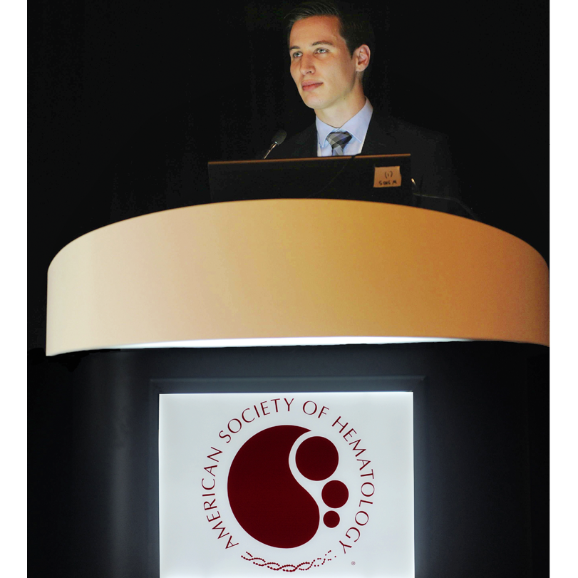 Foto van Jurjen Versluis achter een spreektafel van de American Society of Hematology